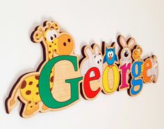 the word george spelled in wooden letters with giraffes and zebras on them