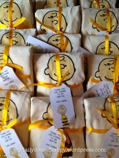 many bags with tags tied to them are stacked on top of each other and wrapped in yellow ribbon