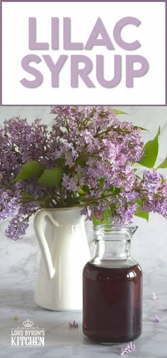 lilac syrup in a white pitcher next to a glass jug filled with purple flowers