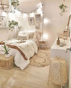 a bedroom with white walls and wooden flooring, plants on the wall above the bed