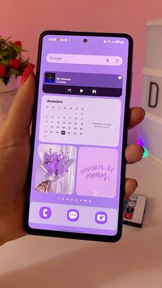 a person holding up a phone with the calendar on it and flowers in vases