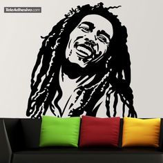 a living room with a couch and large wall decal featuring a drawing of bob marley