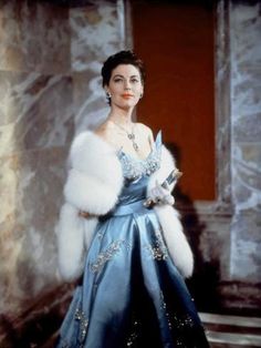 a woman in a blue dress and fur stole