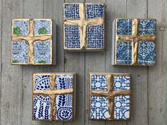 four blue and white decorated cookies sitting on top of a wooden table next to each other