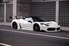 a white sports car parked in front of a building