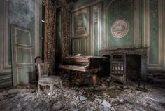 an old room with a piano, chair and fireplace covered in debris from the fire