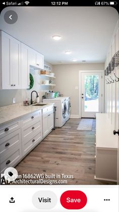 a clean kitchen with white cabinets and wood flooring is seen in this image from the front door