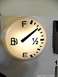 a white clock mounted to the side of a wall