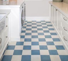 a blue and white checkered tile floor in a kitchen with an oven, washer and dryer