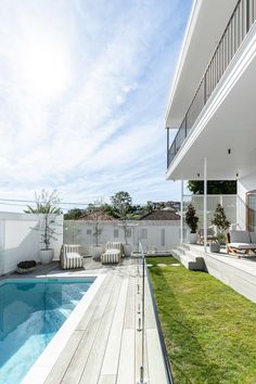 an empty backyard with a swimming pool and deck area next to the home's lawn