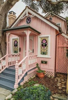 a pink house with stained glass windows on the front door and steps leading up to it