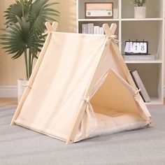 a teepee tent sitting on top of a rug in front of a book shelf