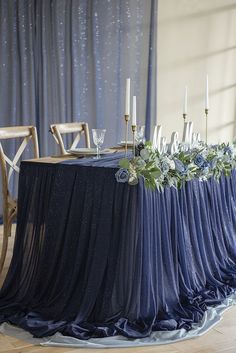 the table is set up with candles and flowers on it for an elegant wedding reception