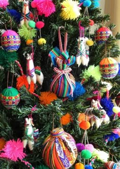 a christmas tree decorated with brightly colored ornaments and pom - poms on it