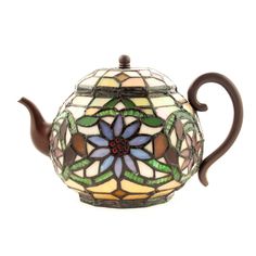 a stained glass teapot with a red handle and flower design on the top, sitting on a white surface