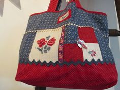 a red, white and blue bag hanging from a hook on a wall next to a ladder