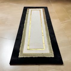 a black and white rug with gold trim