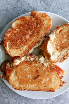 three grilled cheese sandwiches on a white plate