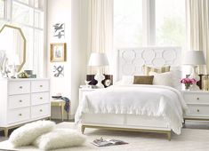 a bedroom with white furniture and large windows