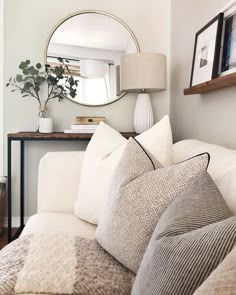 a living room with a couch, mirror and table