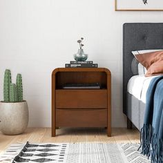 a bedroom with a bed, nightstand and cactus