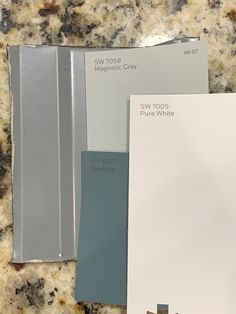 three different shades of paint sitting on top of a marble countertop next to each other