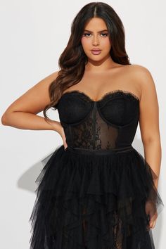 a woman wearing a black corset with sheer tulle