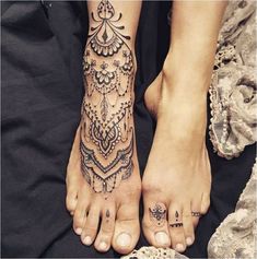 two people with tattoos on their feet and one is holding the other's hand