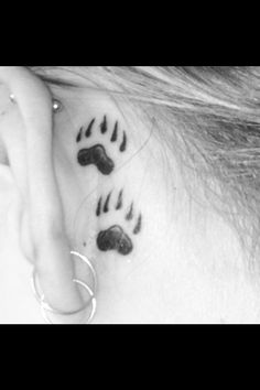 a woman's behind the ear with black and white animal footprints on her left side