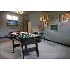 an indoor game room with foosball and basketball hoop