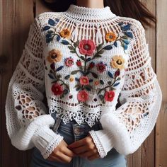 a doll wearing a white sweater with flowers on it