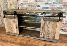 an entertainment center made out of wood with metal handles and sliding doors on the sides