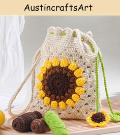 a crocheted bag with yarn and flowers on the front, along with two balls of yarn