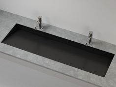 two chrome faucets mounted to the side of a gray counter top in a bathroom