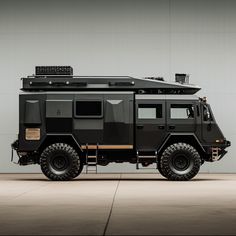 the armored vehicle is parked in front of a gray wall with lights on it's roof