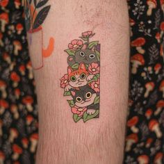 a person with a tattoo on their leg has flowers and cats in the letter i