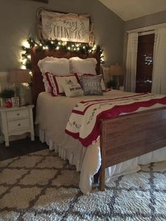 a bedroom decorated for christmas with lights on the headboard and bed in front of it