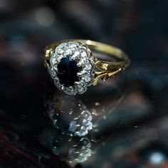 an antique diamond and sapphire ring sits on a table