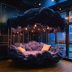 a bed made to look like a cloud with lights hanging from it's sides