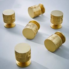 six brass knobs with designs on them sitting on a white surface, all in the same pattern