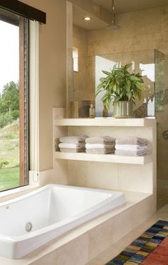 a bathroom with a large bathtub next to a window and a rug on the floor