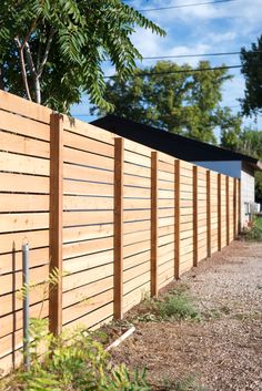 a long wooden fence next to a dirt road