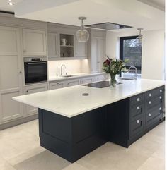 a large kitchen with an island in the middle and lots of cabinets on both sides