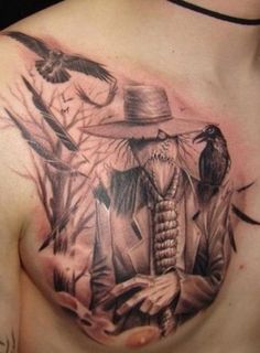 a man's chest with tattoos on it and birds flying around him, while he is wearing a cowboy hat