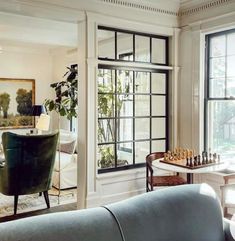 a living room filled with furniture and a chess board on top of a coffee table