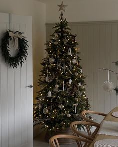 a decorated christmas tree sitting next to a dining room table