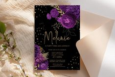 a black and gold birthday party with purple flowers on the front, white envelope and card