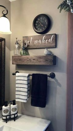 a bathroom with a sink, towel rack and clock above the sink is decorated in black and white striped towels