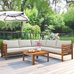 a couch and table on a deck with an umbrella