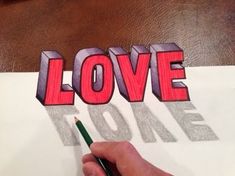 someone is drawing the word love with a pencil